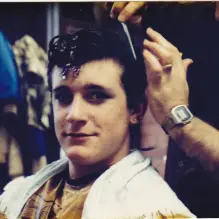 One of the actors in Grease (1984) getting his hair styled.
